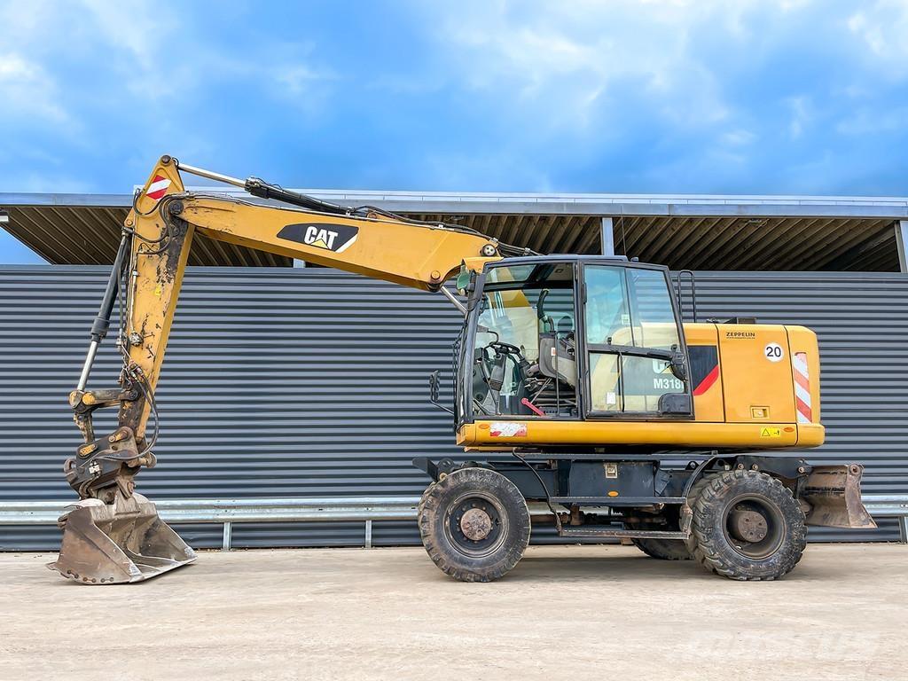 CAT M318F Pelle sur pneus